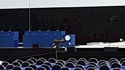 empty conference room stage showing presiding table and lectern with fixed microphones